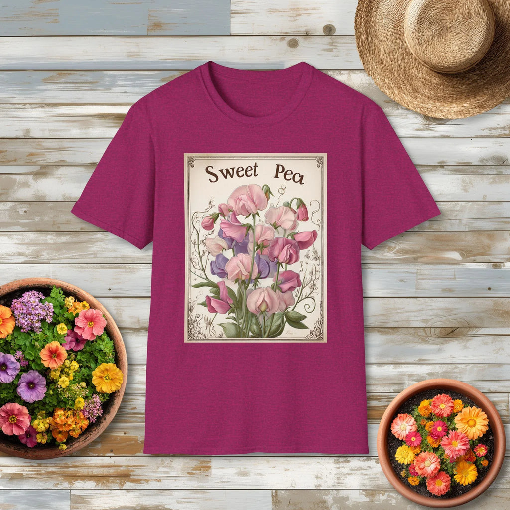 Dark pink t-shirt with 'Sweet Pea' seed packet art on a wooden surface with flower pots and a hat.